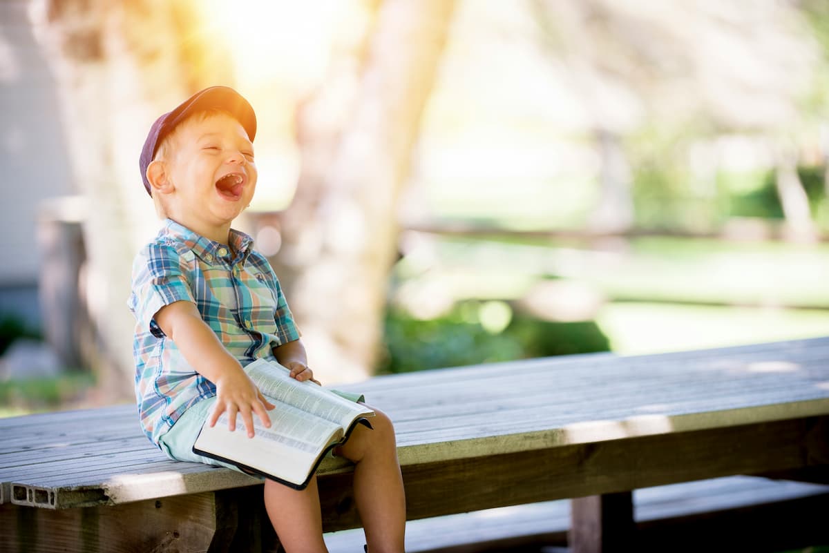 Child laughing whilst reading